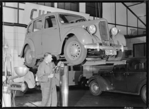 Garage attendant greasing a Hillman Minx car, Todd Motors, Wellington