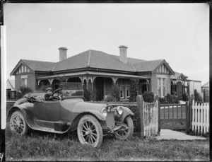 Boy in a Buick car, outside a house in Hastings