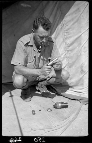 New Zealand soldier with an Italian thermos bomb, Egypt, during World War 2
