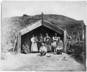 Pulman, Elizabeth, 1836-1900 : Photograph of a Maori group, including guides, outside a whare in the Rotorua district