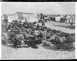 Wounded New Zealand soldiers on stretchers outside 5 New Zealand Field Ambulance tents, Western Desert, during World War 2 - Photograph taken by K G Killoh