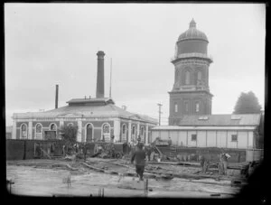 Workmen working on a site next to the Invercargill Waterworks and water tower