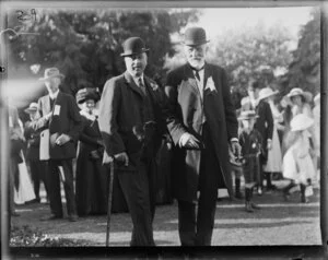 Two unidentified men at a public gathering, location unknown