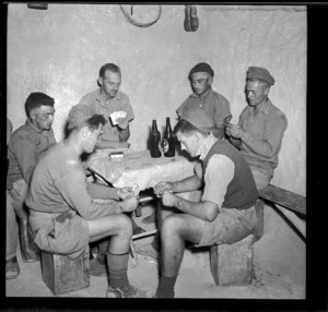 New Zealand soldiers playing cards in the corner of a dugout, during World War II
