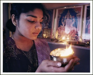 Hindu woman Narmadai Chinniah holding a prayer lamp - Photograph taken by Ross Giblin