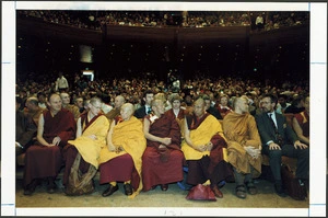 Buddhist monks, and others, seated in the Michael Fowler Centre, waiting for the Dalai Lama to arrive