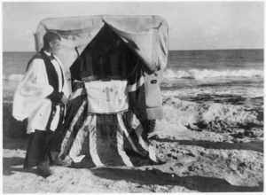 Padre Holland by an improvised altar on the beach at Nofilia, Tripolitania, Libya, during a Christmas Day service for World War 2 New Zealand troops - Photograph taken by C A Churchill