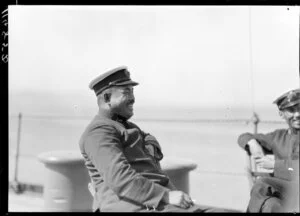 Decorated naval officer seated on ship's deck