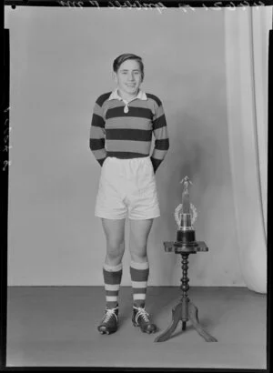 Mr P. Gribble in rugby uniform with trophy