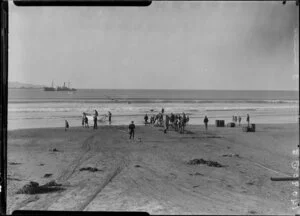 Men laying rope and digging trench down beach, Lyall Bay, Wellington