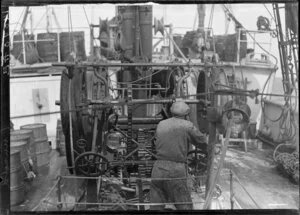 Unidentified man operating machinery on deck of Tutanekai