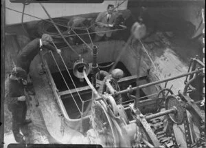 Unidentified workmen looking into hold on deck of Tutanekai