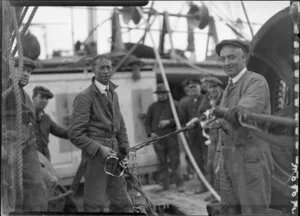 Unidentified men posing with unravelled cable, on board the Tutanekai
