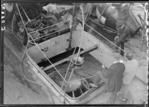 Unidentified men looking into the hold of the Tutanekai