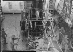 Unidentified men inspecting machinery on the deck of the Tutanekai