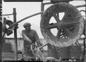 Unidentified man operating machinery to lay cable, deck of Tutanekai