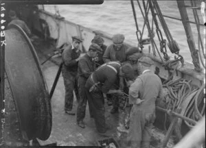 Unidentified men splicing cable on deck of Tutanekai