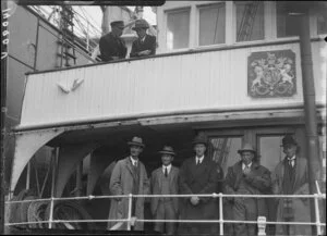 Men in suits & hats on two decks of ship