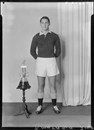 Mr T. Mataria in rugby uniform with trophy