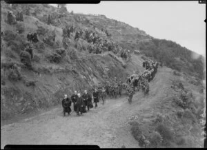 Coffin draped with N.Z. flag & kiwi feather cloak, military funeral procession