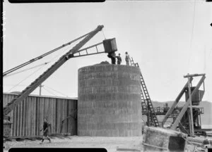 Crane dumping rocks in large tank, Wellington
