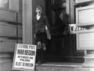 Newspaper boy and an advertising signboard which reads - War Begun