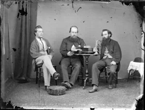 Three unidentified men, one holding a cornet