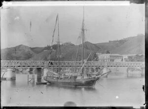 Scow moored in the Whanganui River beside the Victoria Avenue bridge, looking towards the Red Lion Hotel, Taylorville, on the eastern bank of the river