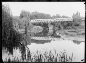 Bridge over the Te Arai River, Poverty Bay, Gisborne Region, featuring willow trees, rushes and a strong reflection of the scene in the water