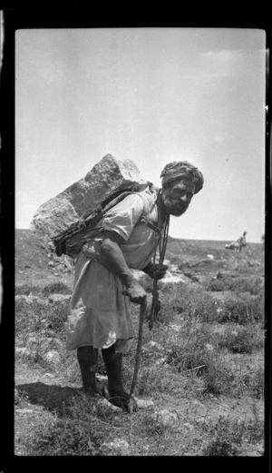 Palestinian workman carrying a stone slab on his back