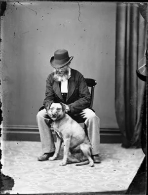 Unidentified man, seated, with his dog