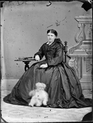 Mrs Quick, seated with a dog looking rather like a teddy bear