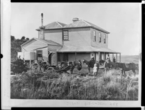 Two-storied wooden house with wide verandah, people and horses in the front yard, Wanganui