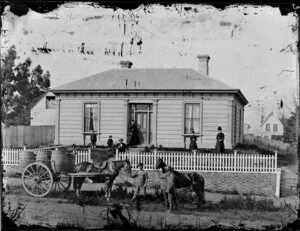 People outside house, white picket fence, men standing on road with two horses and cart, Wanganui