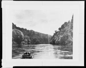 View from a boat on a large unidentified river with bush covered hills on both sides
