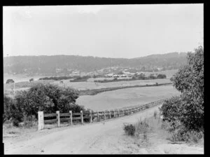 View of an unidentified settlement on a wooded hill with a river in the foreground, Australia
