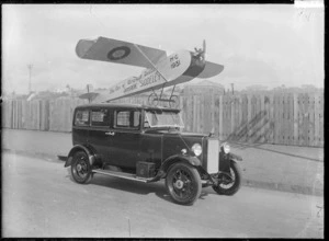 A decorated Armstrong-Siddeley with a model airplane on its roof