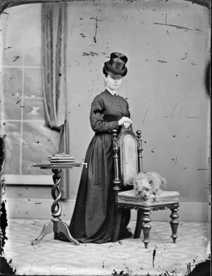 Unidentified woman wearing a top hat, with her dog