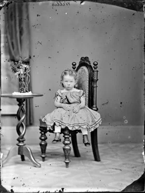Miss Willis as a toddler sitting on a chair