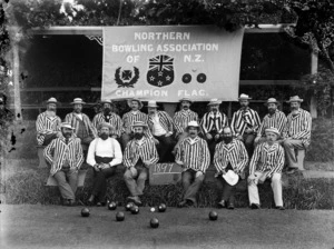 Bowlers seated underneath the Northern Bowling Association of N Z's champion flag, Wanganui District