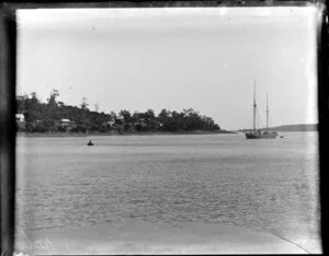 Man in a rowing boat and a sailing ship next to a small settlement, [Australia]