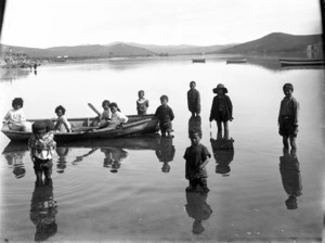 Group of Maori children playing in shallow water