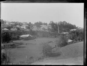 Grafton, Auckland, featuring the bowling green, where a game is being played and the green maintained with a roller, while Grafton Road, and houses are in the background