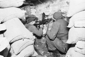 Kaye, George 1914- : Soldiers of 23rd NZ Battalion, firing a Bren machine gun from a house in the Faenza area, Italy