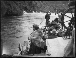 Maori women carrying a child on her back, on board a boat on the Whanganui River
