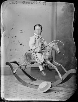 H Peacock, son, about 3, on rocking horse