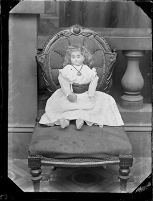 Toy doll seated on a chair