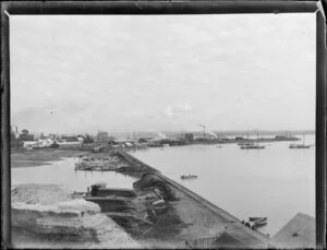 Mechanics Bay, Auckland, including boats moored in the harbour, milled timber and logs, factories, and railway wharf