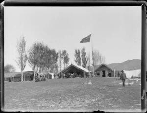 Scene during the Maori parliament (Kotahitanga) at Pakirikiri Pa, Gisborne Region, featuring the meeting house and New Zealand flag