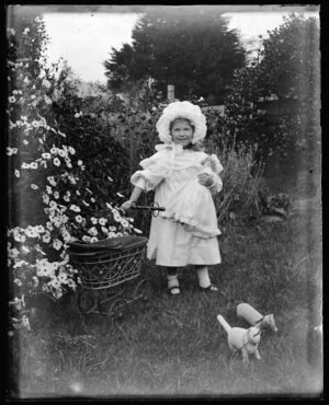 Small girl in garden with toys